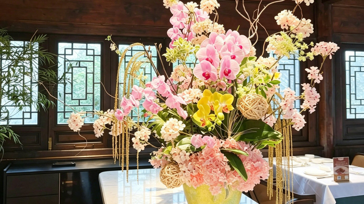 Artificial orchid event arrangement with pink and yellow phalaenopsis in a large vase