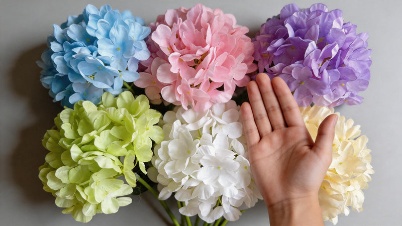Large 54-petal artificial hydrangea-style flower heads shown with a hand for scale